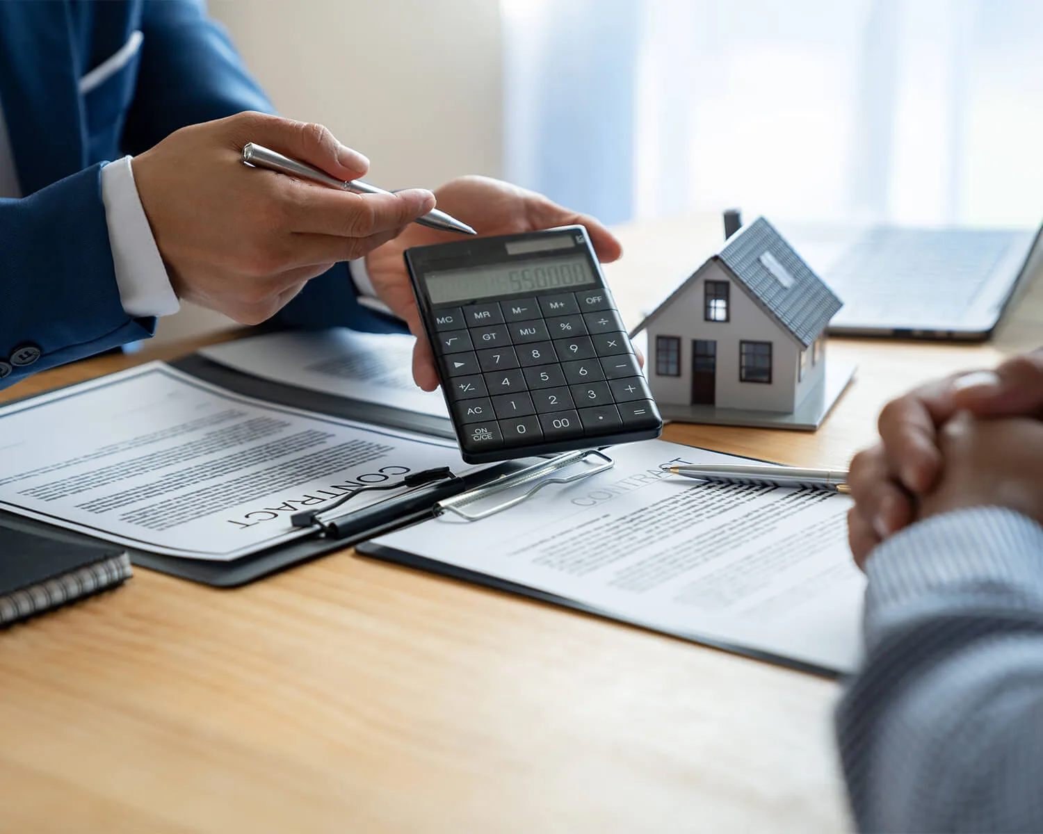 Contrat, calculatrice et maquette de maison pour la gestion locative